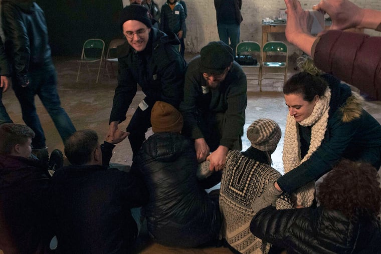 Protesters play the roles of ICE agents while other protesters are seated. Philly's respected city solicitor, Harvard law grad Sozi Pedro Tulante, an immigrant from what is now called the Democratic Republic of Congo, said that Philly would turn over a suspected undocumented immigrant, already under arrest, if the feds present a warrant.