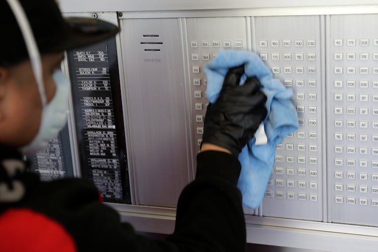 Guadalupe Lucero, a member of the janitorial staff, wipes down high-touch surfaces at a building in Co-op City in the Bronx, New York.