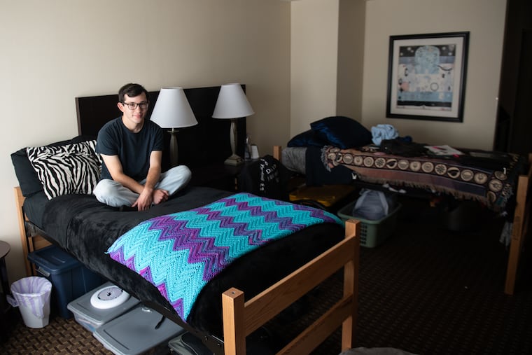 James Henry, 19 and a sophomore, sits in his dorm room at the Best Western at Widener University. The college replaced the standard-issue hotel beds with twin XLs, though the abstract hotel art remains.