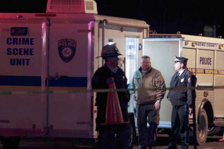 Investigators gather outside the Avalon Court apartments in Bucks County. Six residents were displaced by the search into the cause of two deaths. JOSEPH KACZMAREK /For the Inquirer