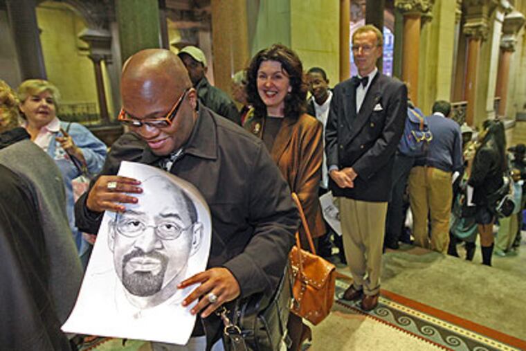 Eric Robinson of Lansdowne looks a the portrait of Nutter that an artist was giving out to people in line. He was hoping that Nutter would sign it.