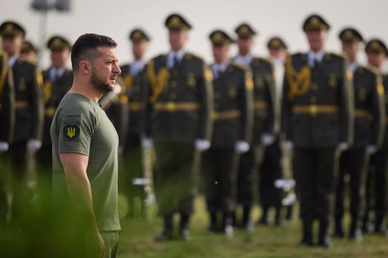 In this photo provided by the Ukrainian Presidential Press Office, Ukrainian President Volodymyr Zelenskyy stands in front of lined up soldiers as he arrives for State Flag Day celebrations in Kyiv, Ukraine, Tuesday, Aug. 23, 2022.