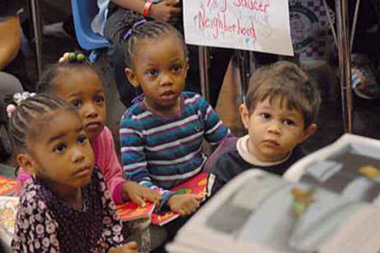 Youngsters at Bache-Martin Elementary School in North Philadelphia listen as a book is read to them. A new report says the school district does not have enough students to fill all of its empty seats. (April Saul / Staff Photographer / File)