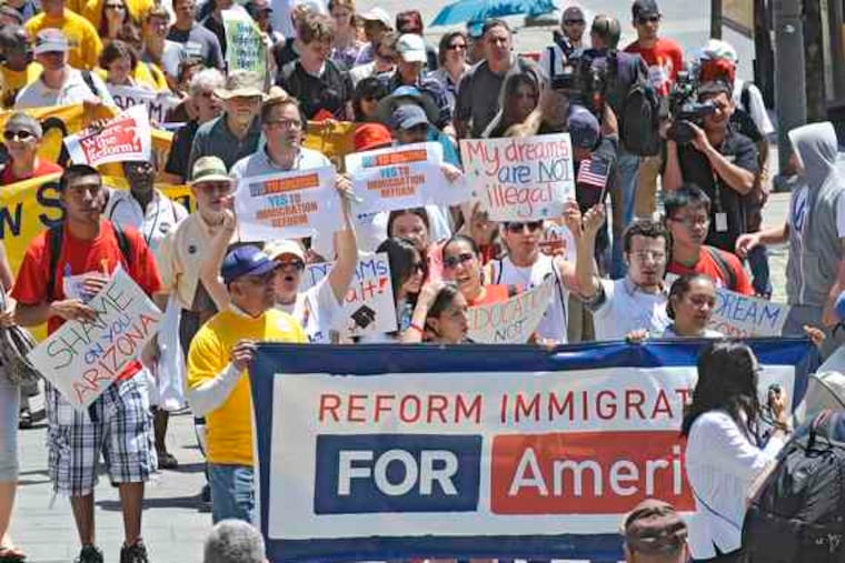 Protesters march up Market Street to Independence Mall in the "From Philly to Phoenix" rally Wednesday. They denounced Arizona's crackdown on illegal immigration and called on President Obama to honor his campaign pledge to bring about comprehensive reform. B7.