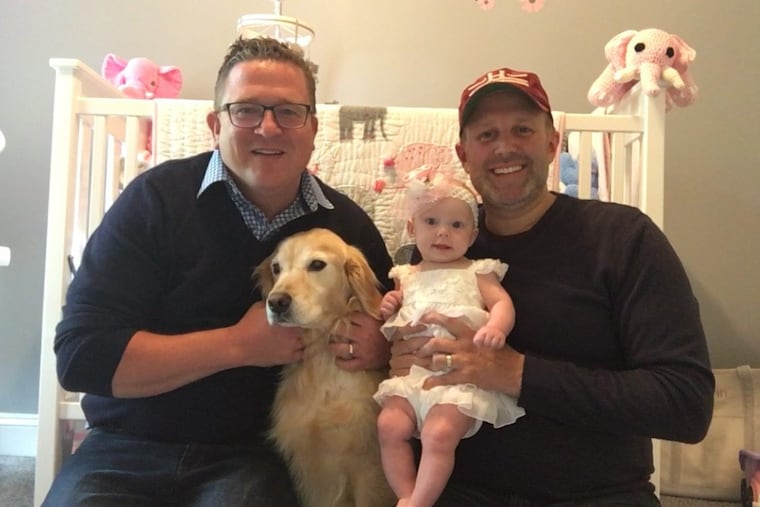 Chris Urban (left), with dog Marshmellow, husband Joe Sena and baby Quinn.