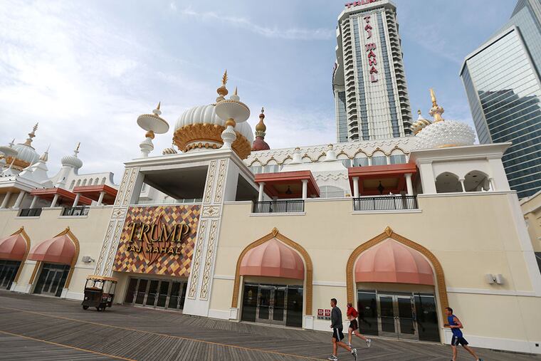 Joggers pass in front of the Trump Taj Mahal in Atlantic City on Wednesday, November 5, 2014. ( DAVID SWANSON / Staff Photographer )
