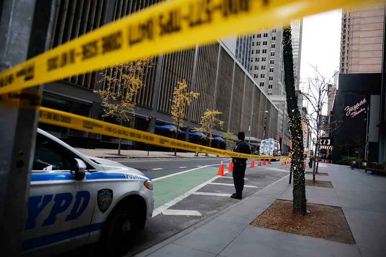 A New York police officer stands on 54th Street outside the Hilton Hotel in Midtown Manhattan where Brian Thompson, the CEO of UnitedHealthcare, was fatally shot on Dec. 4.