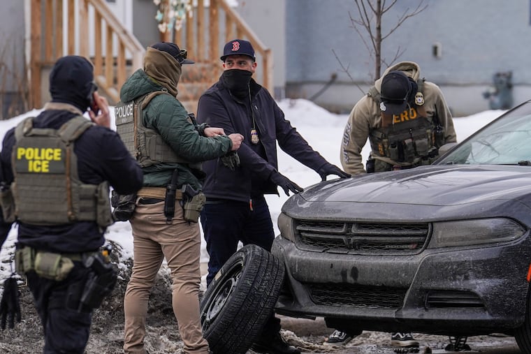 Federal agents tend to a vehicle with a flat tire while conducting immigration enforcement operations in Minneapolis last month.