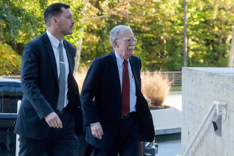 Former Trump administration national security adviser John Bolton, right, arrives for his arraignment at the Greenbelt Federal Courthouse in Greenbelt, Md., on Friday.