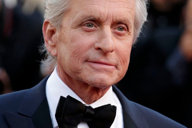 FILE - Actor Michael Douglas poses for photographers as he arrives for the screening of Behind the Candelabra at the 66th international film festival, in Cannes, southern France, in this May 21, 2013 file photo. The Guardian newspaper published an interview Monday June 3, 2013 in which Douglas blamed cunnilingus for the grave malady that was diagnosed in 2010. The newspaper also quoted doctors who were skeptical about his claim. (AP Photo/David Azia, File)