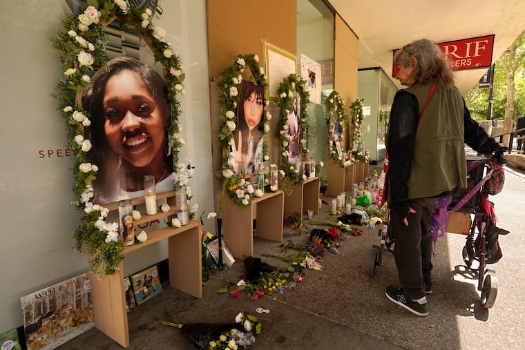 A passerby pauses at a memorial for the six people killed in mass shooting in Sacramento, Calif., on Wednesday, April 6, 2022. Multiple people were killed and injured in the shooting that occurred Sunday, April, 3, 2022. (AP Photo/Rich Pedroncelli)