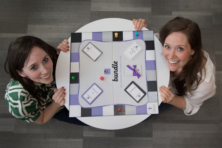 Cassie (left) and Jacklyn Collier with their board game Bundle, intended to bring friends and families together with nostalgia.