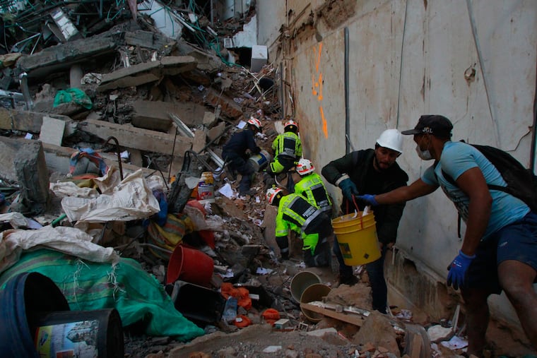 Rescue workers and volunteers clear debris the day after an earthquake struck Pereira, Colombia, Tuesday, Aug. 11, 2026.