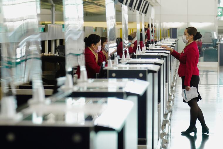 Cathay Pacific ground support members work at the Hong Kong International Airport in Hong Kong Wednesday, Oct. 21, 2020. Hong Kong International Airport said Friday that it would ban passengers from over 150 countries and territories from transiting in the city for a month, as it sought to stem the transmission of the highly contagious omicron variant of the coronavirus.