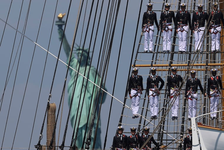 The Statue of Liberty is seen as sailors of a tall ship sail past in the New York harbor during the International Parade of Sail, part of Sail250, a gathering of tall ships and military ships, Saturday, July 4, 2026, in New York.