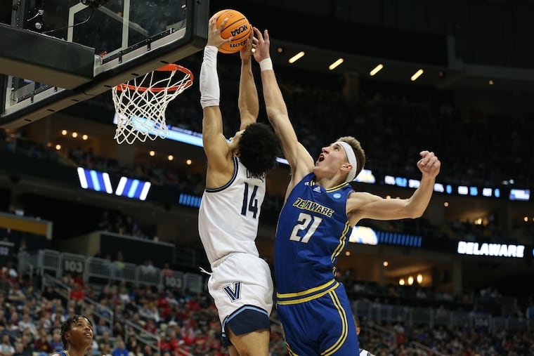 Villanova's Caleb Daniels (left) rises for a dunk as Delaware's Andrew Carr tries to defend him. The Wildcats won the round-of-64 game, 80-60.