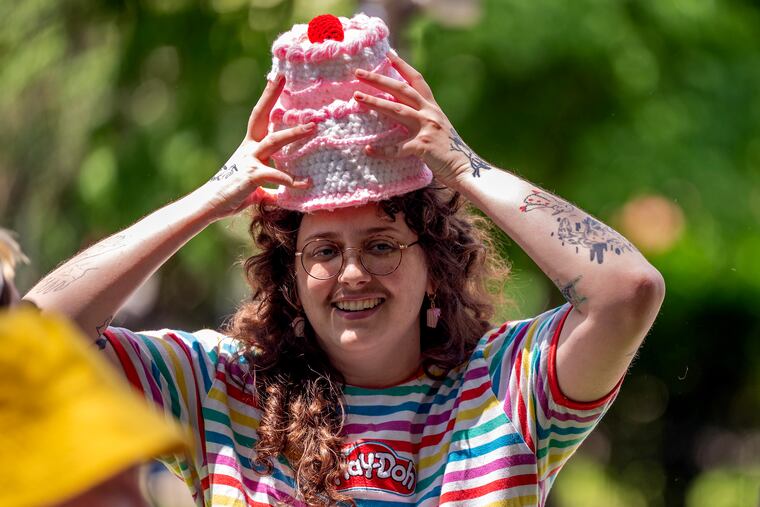 Tufting artist Florian Francis adjusts a custom-knit cake hat while hosting the second iteration of their West Philadelphia cake picnic in Clark Park on Sunday.