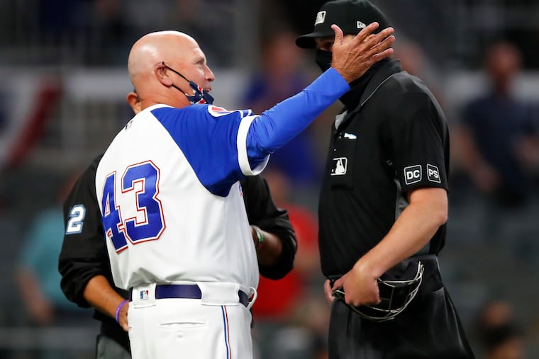 Braves manager Brian Snitker argues the outcome of a replay challenge that upheld a close call at home plate in the ninth inning of the Phillies' 7-6 victory Sunday night in Atlanta.