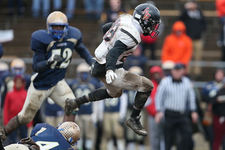 Ryan’s Samir Bullock leaps over George Washington’s Jeffrey Davis during the fourth quarter.