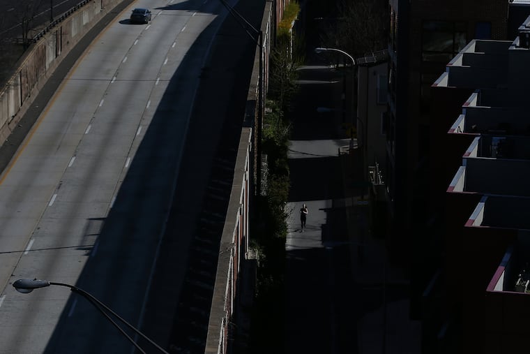 A jogger travels along Front Street as a car heads south on a quiet I-95 in Philadelphia. Work-from-home has reduced the number of commuters on road and rails. Do you miss commuting, or do you hope never to commute again? We want to hear from you.