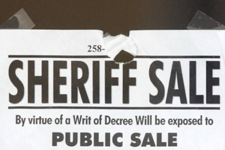 A sheriff sale notice is taped to the window of American Loft between 2nd and 3rd on Brown Street. ( David Swanson / Staff Photographer )
