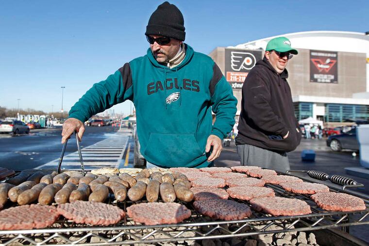 Michael Clay fires a grill laden with sausages, chicken, and burgers for members of the Golden Glove Sports Tour.