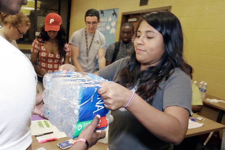 RA Maria Vasquez helps distribute bottled water at Rowan University's Mimosa Hall on Sept. 1, 2016.