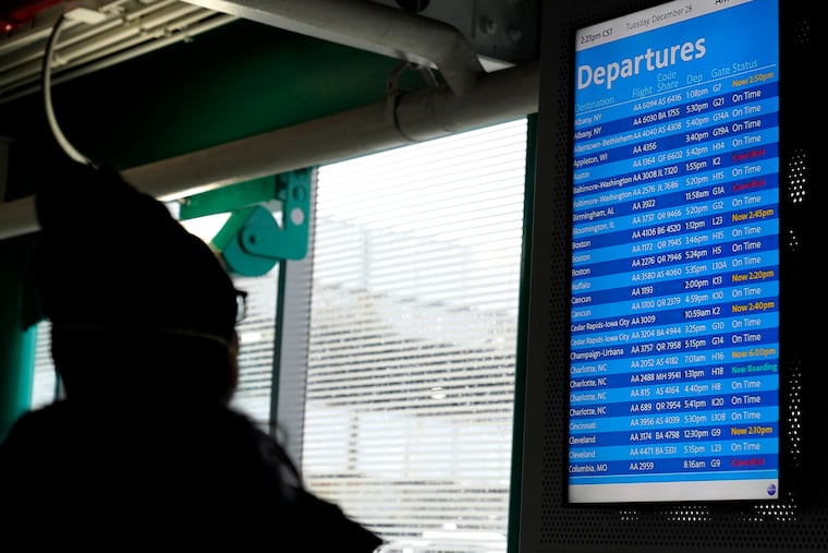 A traveler checks an information screen for flight status at O'Hare International Airport in Chicago on Tuesday.