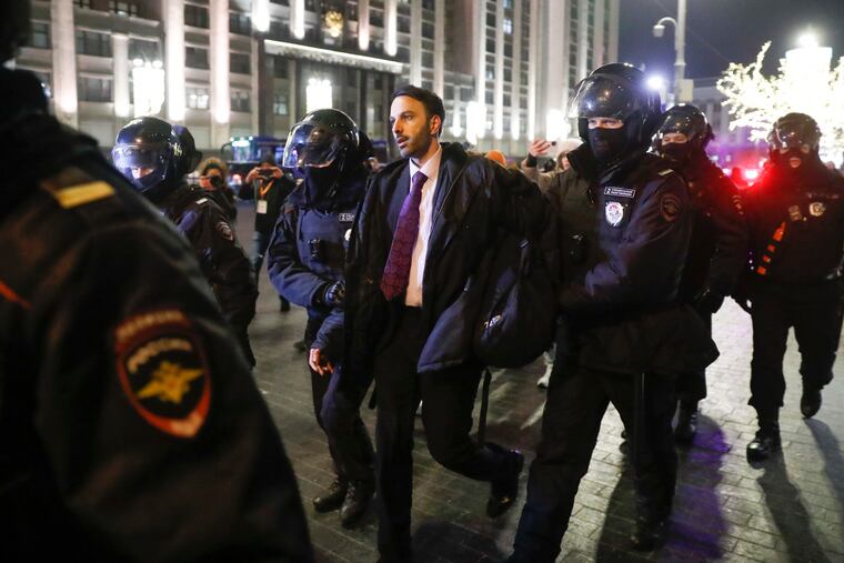 Police officers detain a supporter of Alexei Navalny at the Red Square in Moscow on Tuesday, Feb. 2, 2021. A Moscow court has ordered Russian opposition leader Alexei Navalny to prison for more than 2 1/2 years on charges that he violated the terms of his probation while he was recuperating in Germany from a nerve-agent poisoning.