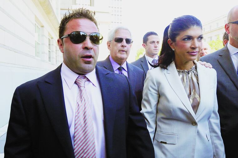 FILE – In this July 30, 2013 file photo, "The Real Housewives of New Jersey" stars Giuseppe "Joe" Giudice, left, and his wife, Teresa Giudice, of Montville Township, N.J., walk out of Martin Luther King Jr. Courthouse after an appearance in Newark, N.J. Joe Giudice is now being deported back to his native Italy.