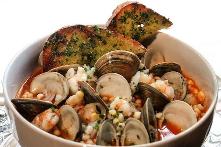 Shellfish in brodo: A stew of rock shrimp, squid, and littlenecks with fregola pasta and sweet corn in a seafood broth flavored by fennel and Calabrian chile butter. (Steven M. Falk/Staff Photographer)
