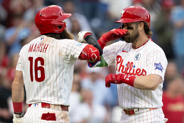 Brandon Marsh congratulates teammate Bryce Harper (right) after Harper's two-run homer in the fourth inning.