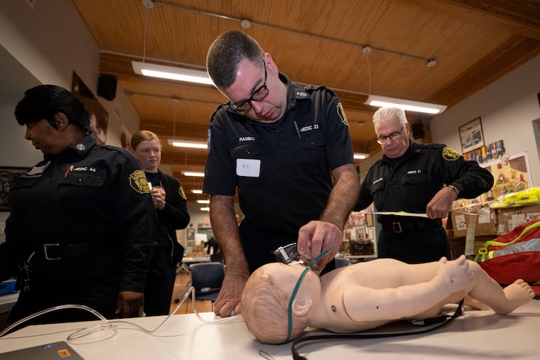 Philadelphia Fire Department EMS worker Anthony Rambo practices medical emergency training on an infant mannequin during a CHOP training at the Second Alarmers Fire Station in Philadelphia. With him are (from left) Elizabeth McCloskey, Tanya Brockenborough, and Andreas Georgiades.