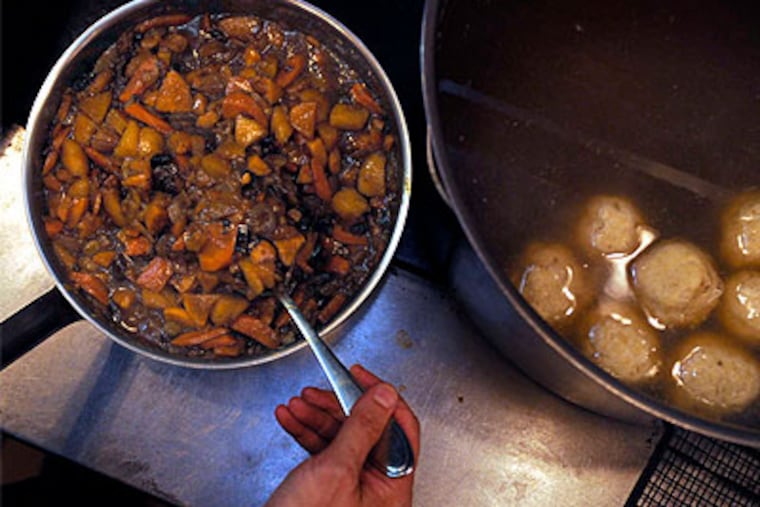 At Supper on South Street , owner Mitch Prensky stirs sweet potato and carrot tzimmes, next to chicken soup with matzo balls. Brisket inspired by his mother has the place of honor. (Tom Gralish / Staff Photographer)