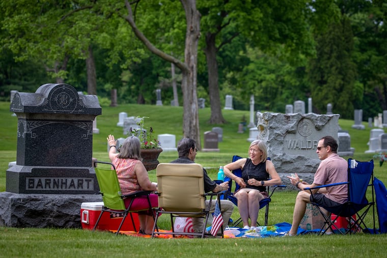 Laura and Jeff Soderquist (left) and Sally and Scott Taylor (right) meet for a picnic at Lakewood Cemetery in Minneapolis last month. They have been meeting at Floyd Barnhart's grave for four years after a serendipitous meeting there.