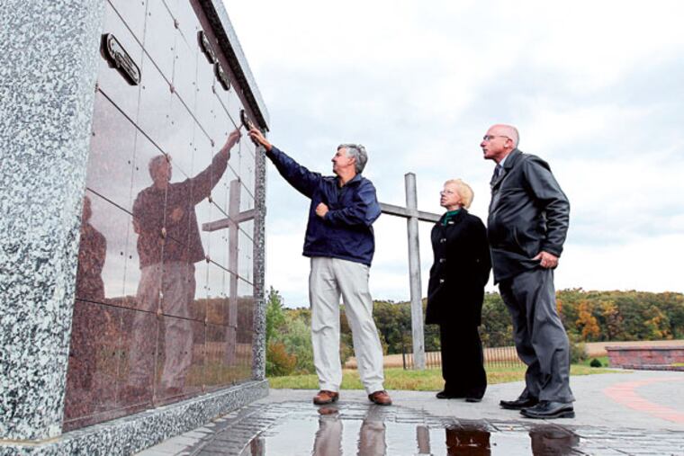 Senior pastor Steve Morton, left, Debra Boyd, center, director of Lay Ministries, and pastor Dan Hepner examine the nameplates on one of the newly constructed columbaria in the Hopewell Cemetery. ( MICHAEL BRYANT / Staff Photographer )