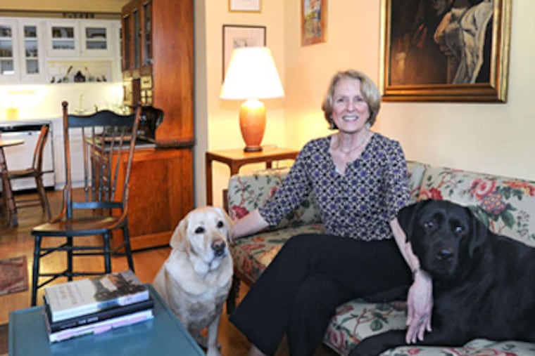Shep Houston in the living room of her Belmont Hills home with her Labrador retrievers Noah (left) and Ranger.