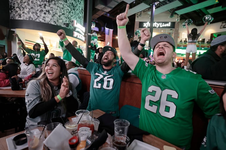 (L-R) Eagles fans Sarah Ahmad of Bridgewater, N.J. Waj Khan of Bridgewater, N.J. and Pat Fiorino of Wildwood cheer wildly when the Eagles score first while watching the Eagles vs. Packers NFL playoff game at XFINITY Live! Philadelphia on Sunday, January 12, 2025.