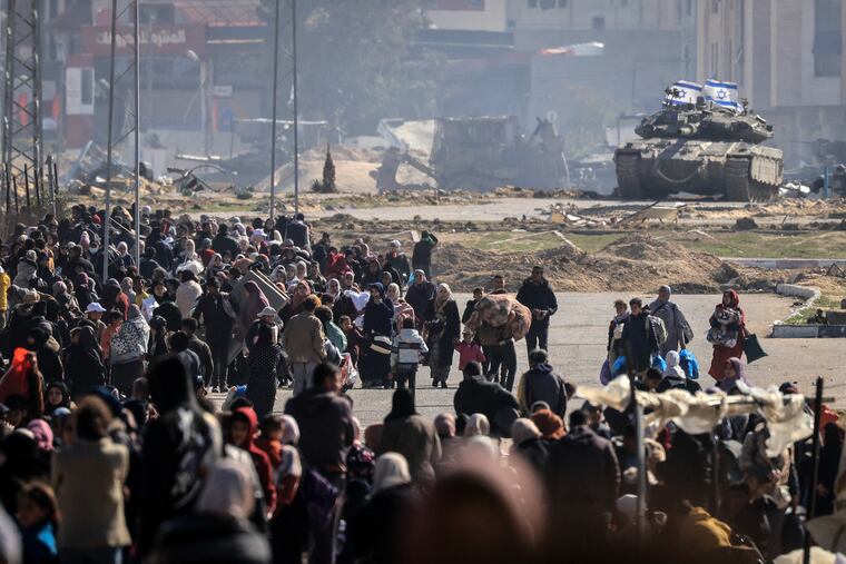 An Israeli tank takes position Friday at the western entrance of Khan Yunis' refugee camp as Palestinians flee with a few belongings to safer areas farther south in the Gaza Strip.