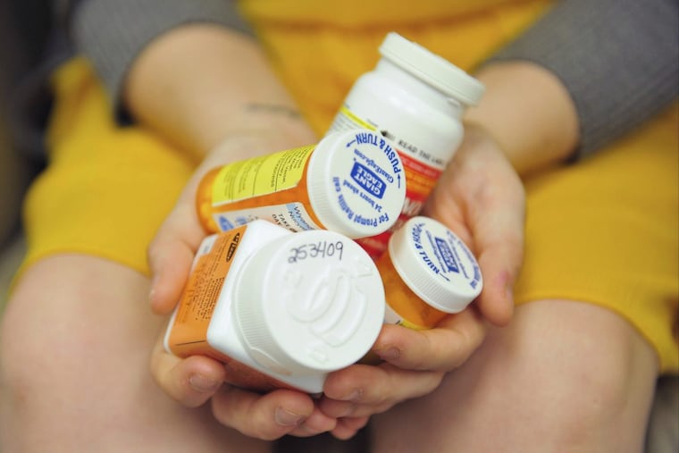 Heidi Wyandt, 27 holds a handful of her medication at the Altoona Center for Clinical Research where she receives experimental non-opioid pain medication for chronic back pain related to a work related injury she received in 2014 on Wednesday, March 29, 2017 in Altoona, PA. (AP Photo/Chris Post)