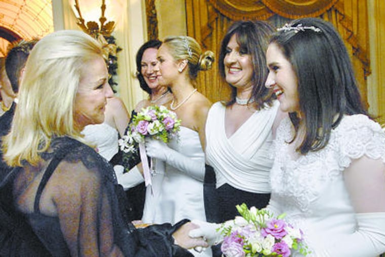 Patricia Byrns-Siganos (left) greets debutante Kelly Slota in the receiving line.