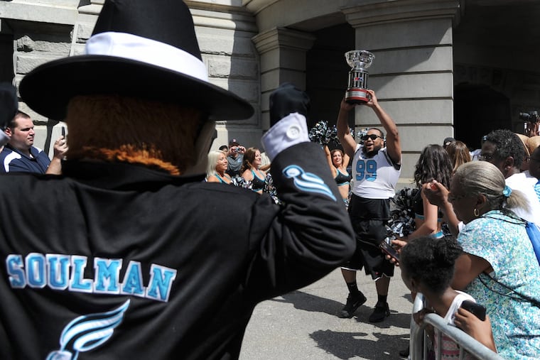 Philadelphia Soul mascot Soulman cheers for defensive lineman Justin Lawrence, carrying out the championship trophy after the Philadelphia Soul won the 2018 ArenaBowl.