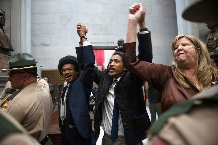 Tennessee state Rep. Justin Pearson, state Rep. Justin Jones and state Rep. Gloria Johnson hold their hands up as they exit the House chamber doors on Monday.