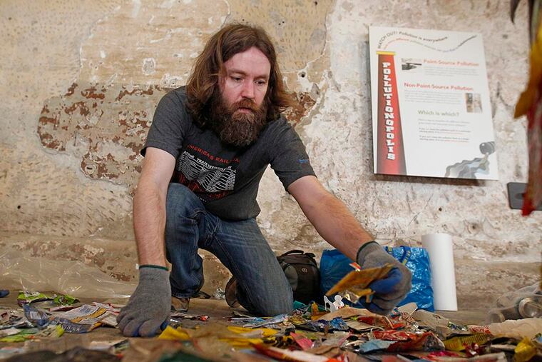 Bradley Maule goes through a pile of plastic bags that he found during his garbage pickups in the Wissahickon Valley so they can be transformed into the "Tower of Garbage" he is creating April 13, 2015.( Michael Bryant / Staff Photographer )