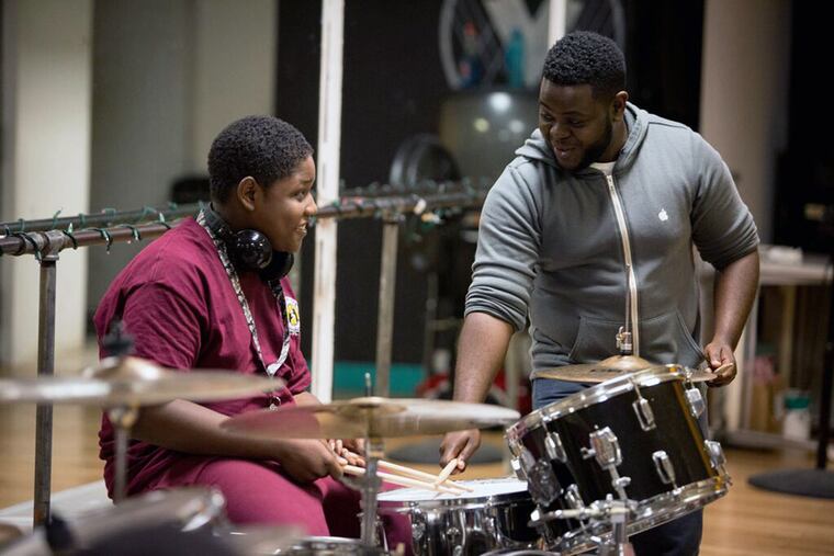 Professional drummer Marcus Myers (right) instructs a lesson at the
Village of Arts & Humanities as part of Philly Drum Project’s free Friday
lessons.