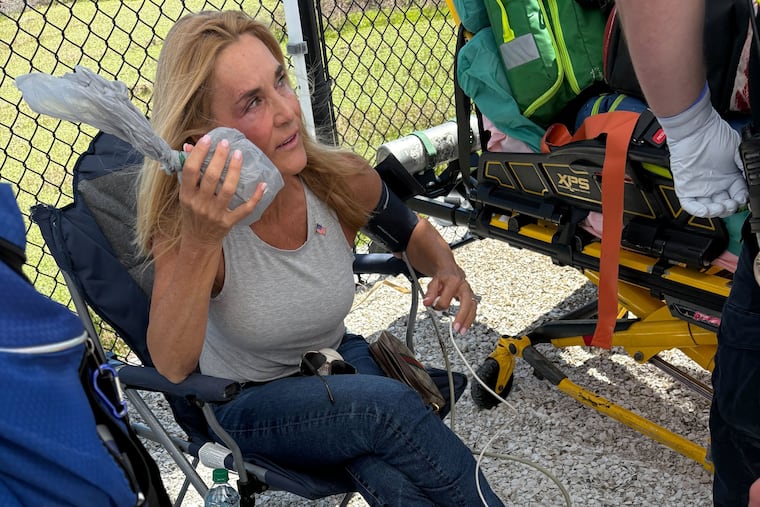 Stacy Durbin, of Clearwater Beach, Fla., holds ice to her eye after getting hit with a home run ball during the Phillies game on Thursday in Clearwater, Fla.