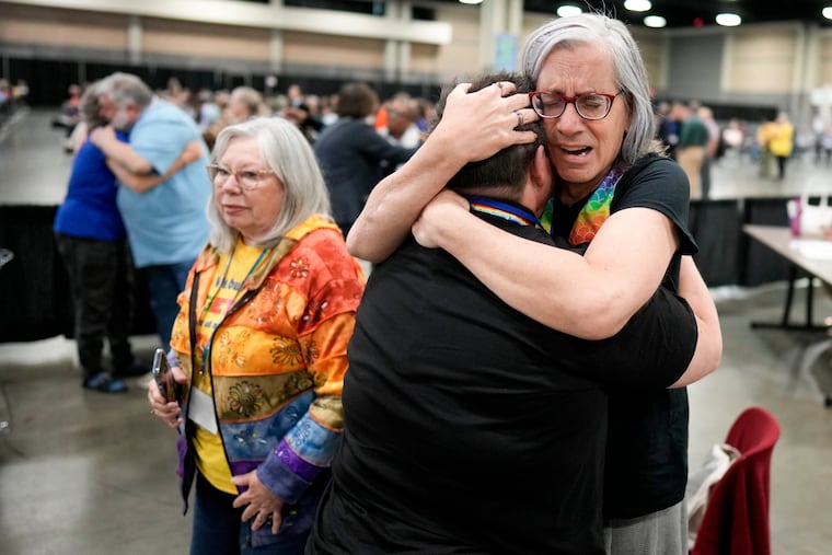 Angie Cox, left, and Joelle Henneman hug after an approval vote at the United Methodist Church General Conference in Charlotte, N.C. United Methodist delegates repealed their church’s longstanding ban on LGBTQ clergy with no debate on Wednesday, removing a rule forbidding “self-avowed practicing homosexuals” from being ordained or appointed as ministers.