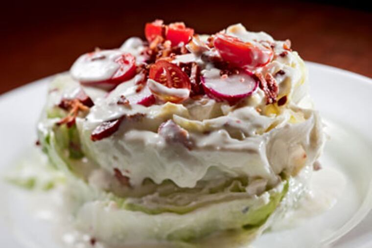 The iceberg salad is reshaped, with blue-cheese dressing, Kentucky bacon, and baby tomatoes. (David M Warren / Staff Photographer)