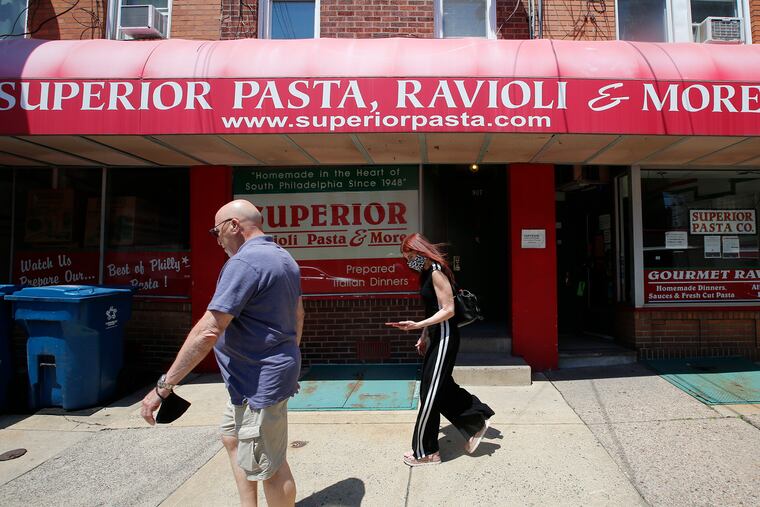 Pedestrians walk past the closed Superior Pasta in the Italian Market.