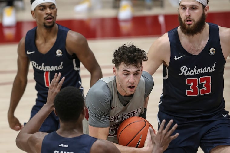St. Joseph's Taylor Funk is surrounded by Richmond's Blake Francis (1), Nathan Cayo and Grant Golden (33) during the second half at the Hagan Arena.